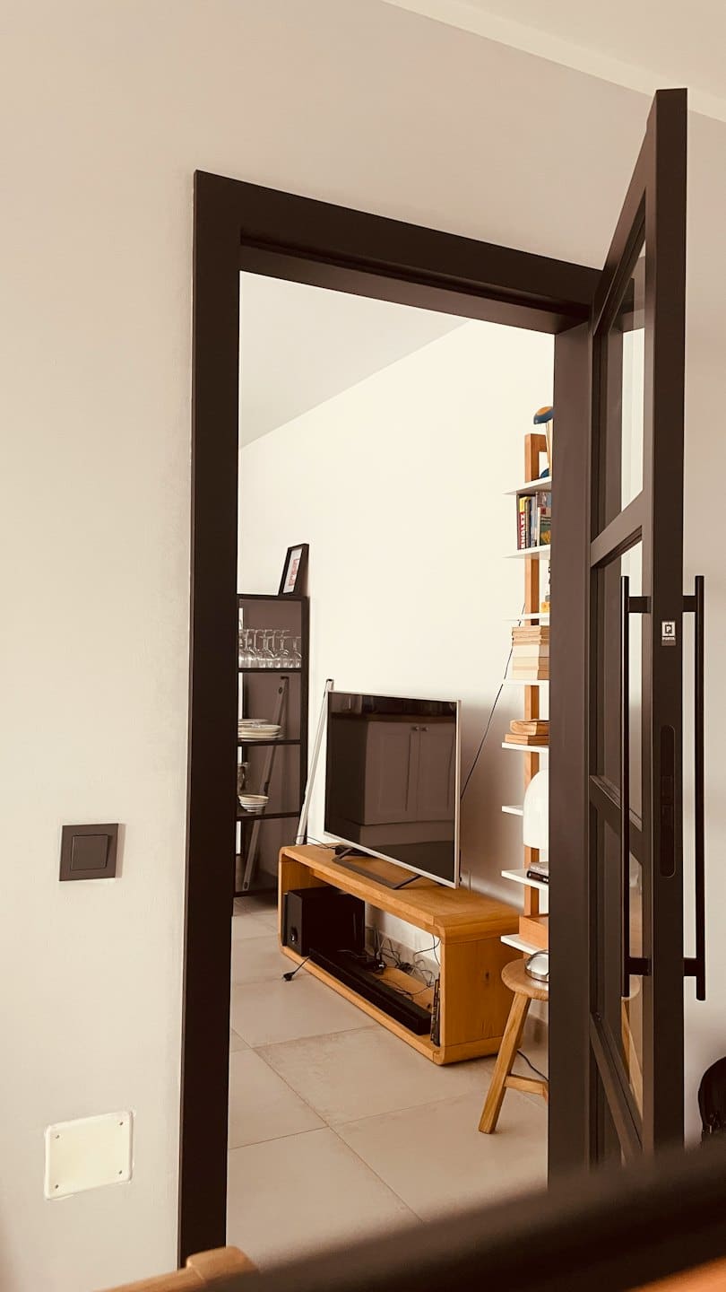 Soggiorno moderno con televisore e librerie.