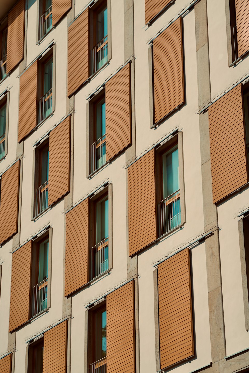 Facciata di un edificio moderno con una griglia di finestre e persiane regolabili.